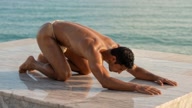 Balasana. Child Pose. Yogi. Greek athlete, sweaty muscle yoga on wet marble 10s